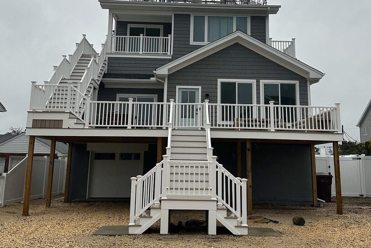 Custom multi-level deck with white railings and staircases by Full Measures LLC in New Jersey